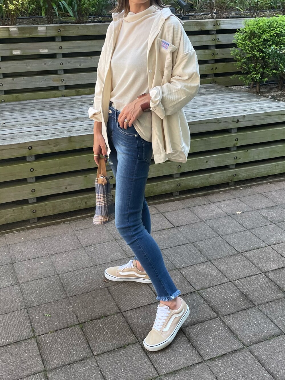 ホワイト系のシャツ/ブラウス、ホワイト系のニット/セーター、ブルー系のデニムパンツを着用したレディースの秋コーディネートの4枚目の写真