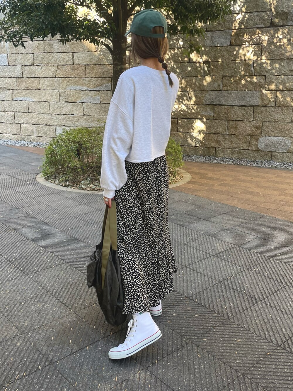 グリーン系のスウェット、ブラック系のスカート、ホワイト系のスニーカーを着用したレディースの冬コーディネートの2枚目の写真