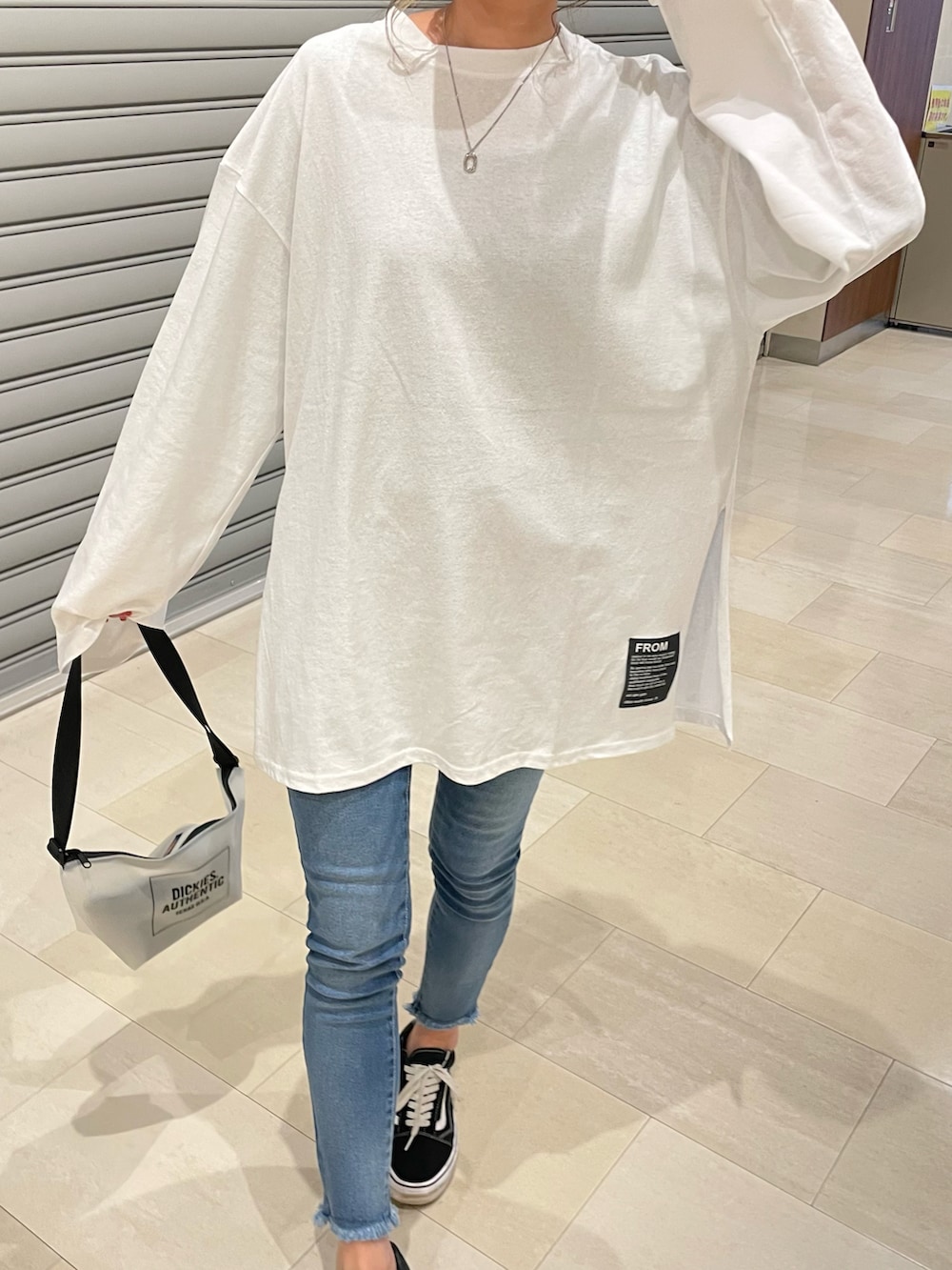 ホワイト系のTシャツ/カットソー、その他のショルダーバッグ、ブラック系のスニーカーを着用したレディースの冬コーディネートの3枚目の写真
