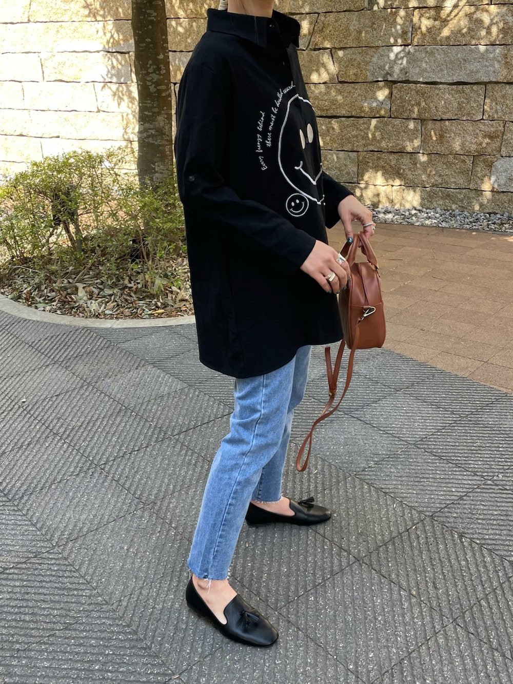 「春服みてみて、デニム、カジュアルコーデ、シャツスタイル、モノトーンコーデ、シャツ、デニムパンツ、ニコちゃん、タッセル、フラットシューズ、ビッグシャツ、はるコーデ、プチプラコーデ、春コーデ、おしゃれさんと繋がりたい」｜「copineの刺繍ニコちゃんオーバーサイズシャツ(ホワイト)（シャツ/ブラウス、ブラック系）」を使った、ayaさん（レディース・161cm）の春コーディネートの3枚目の写真