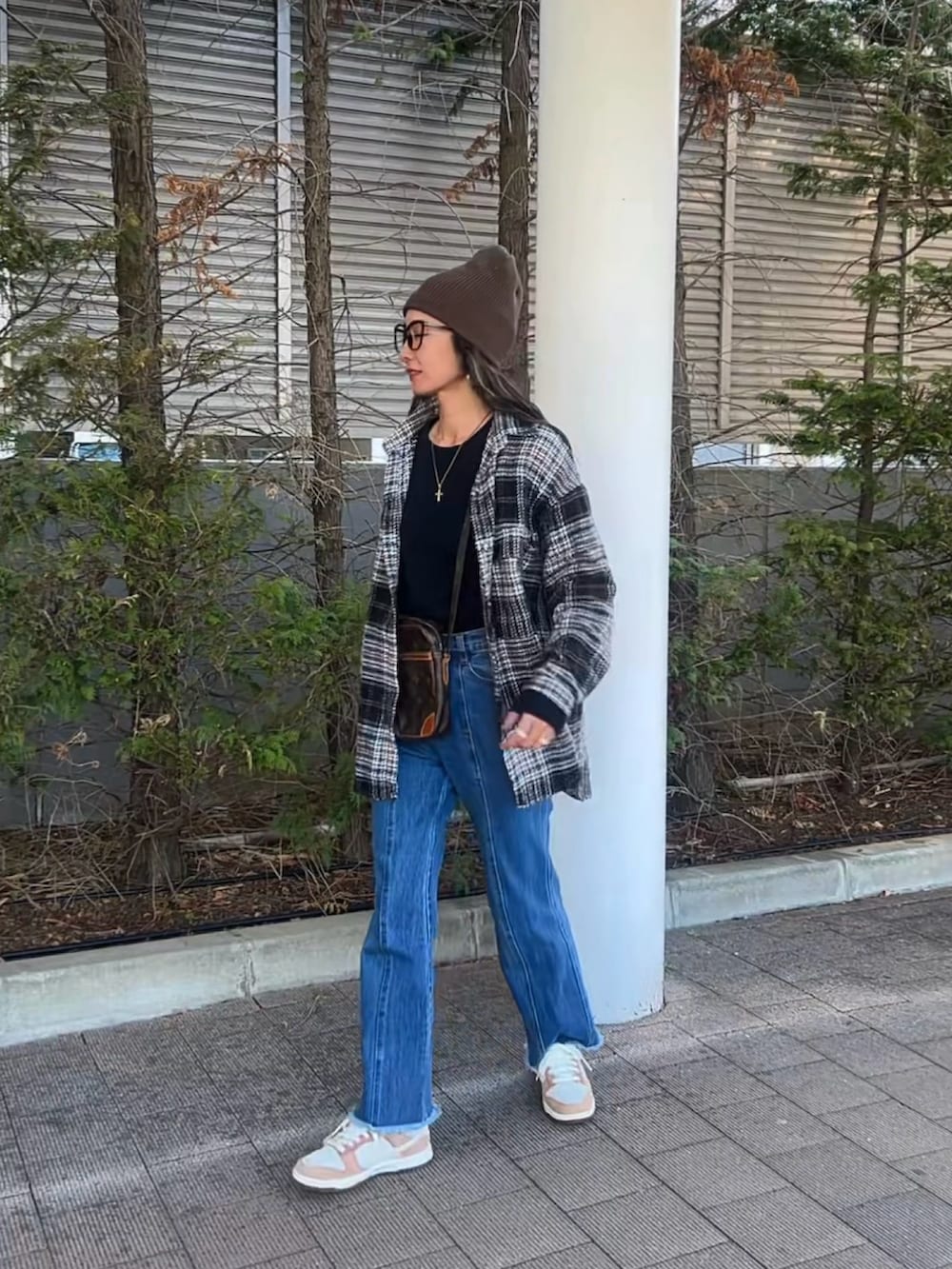 ブラック系のシャツ/ブラウス、ブラック系のTシャツ/カットソー、ブルー系のデニムパンツを着用したレディースの春コーディネートの2枚目の写真