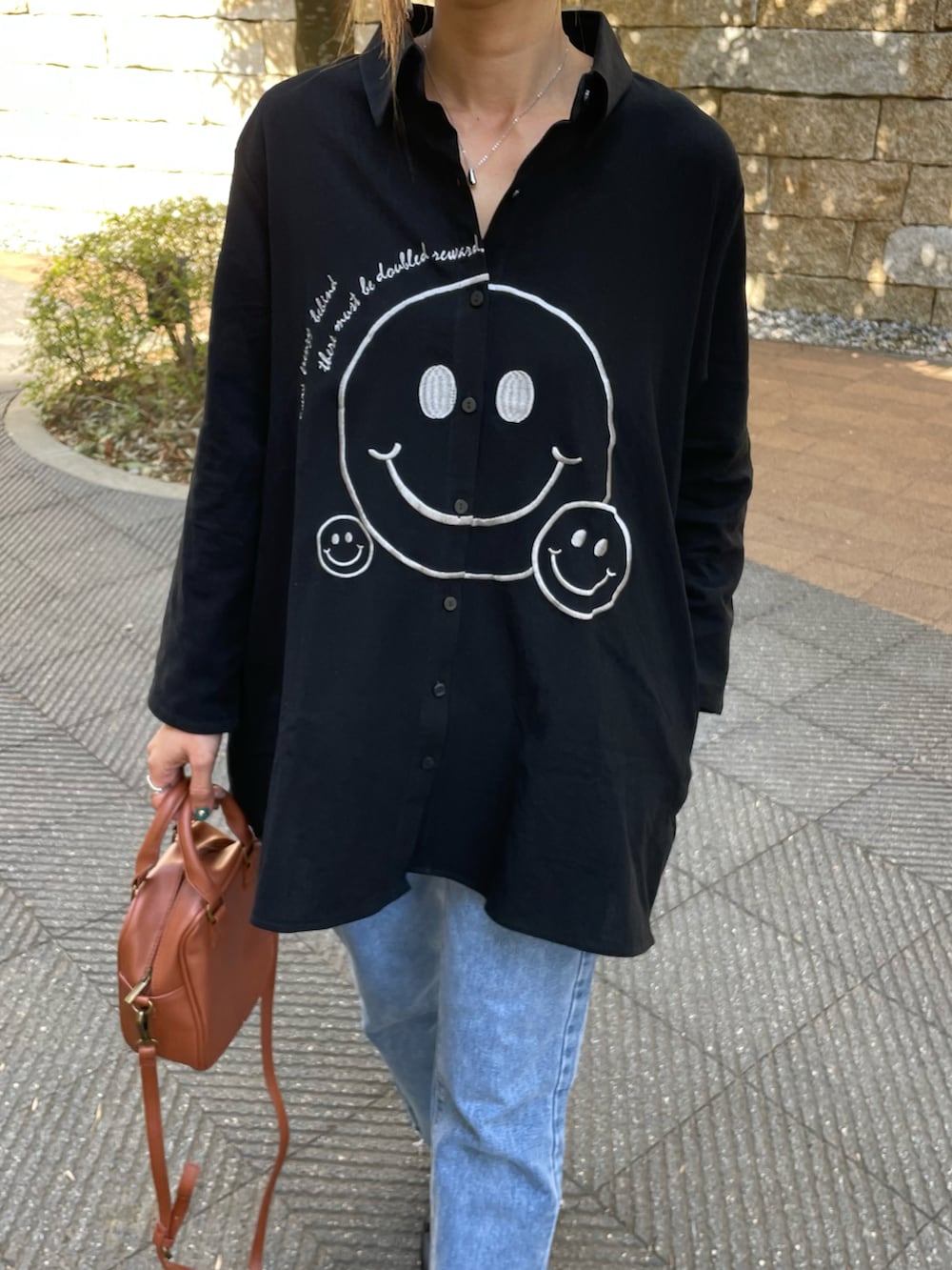 「春服みてみて、デニム、カジュアルコーデ、シャツスタイル、モノトーンコーデ、シャツ、デニムパンツ、ニコちゃん、タッセル、フラットシューズ、ビッグシャツ、はるコーデ、プチプラコーデ、春コーデ、おしゃれさんと繋がりたい」｜「copineの刺繍ニコちゃんオーバーサイズシャツ(ホワイト)（シャツ/ブラウス、ブラック系）」を使った、ayaさん（レディース・161cm）の春コーディネートの4枚目の写真