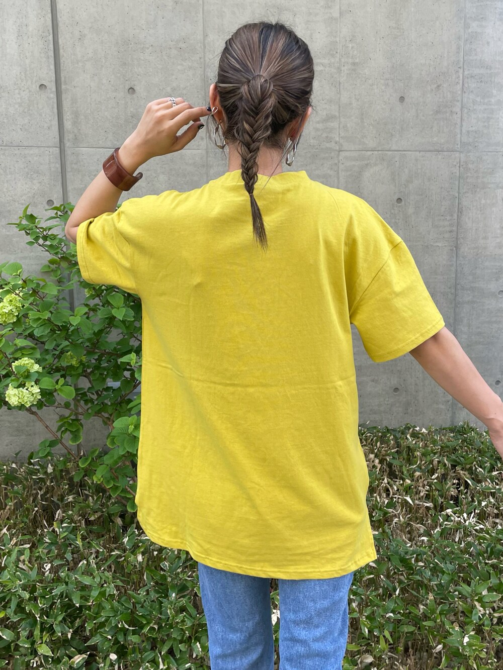 イエロー系のTシャツ/カットソー、ブルー系のデニムパンツ、ホワイト系のスニーカーを着用したレディースの春コーディネートの4枚目の写真