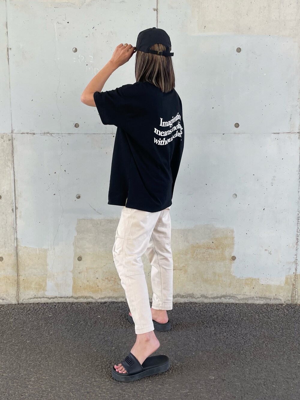 ブラック系のTシャツ/カットソー、ホワイト系のその他パンツ、ブラック系のサンダルを着用したレディースの春コーディネートの2枚目の写真