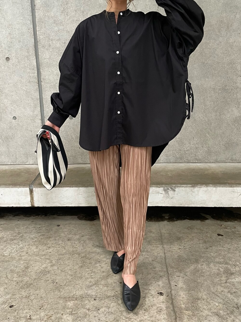 ブラック系のシャツ/ブラウス、ブラウン系のその他パンツ、ブラック系のハンドバッグを着用したレディースの春コーディネートの2枚目の写真