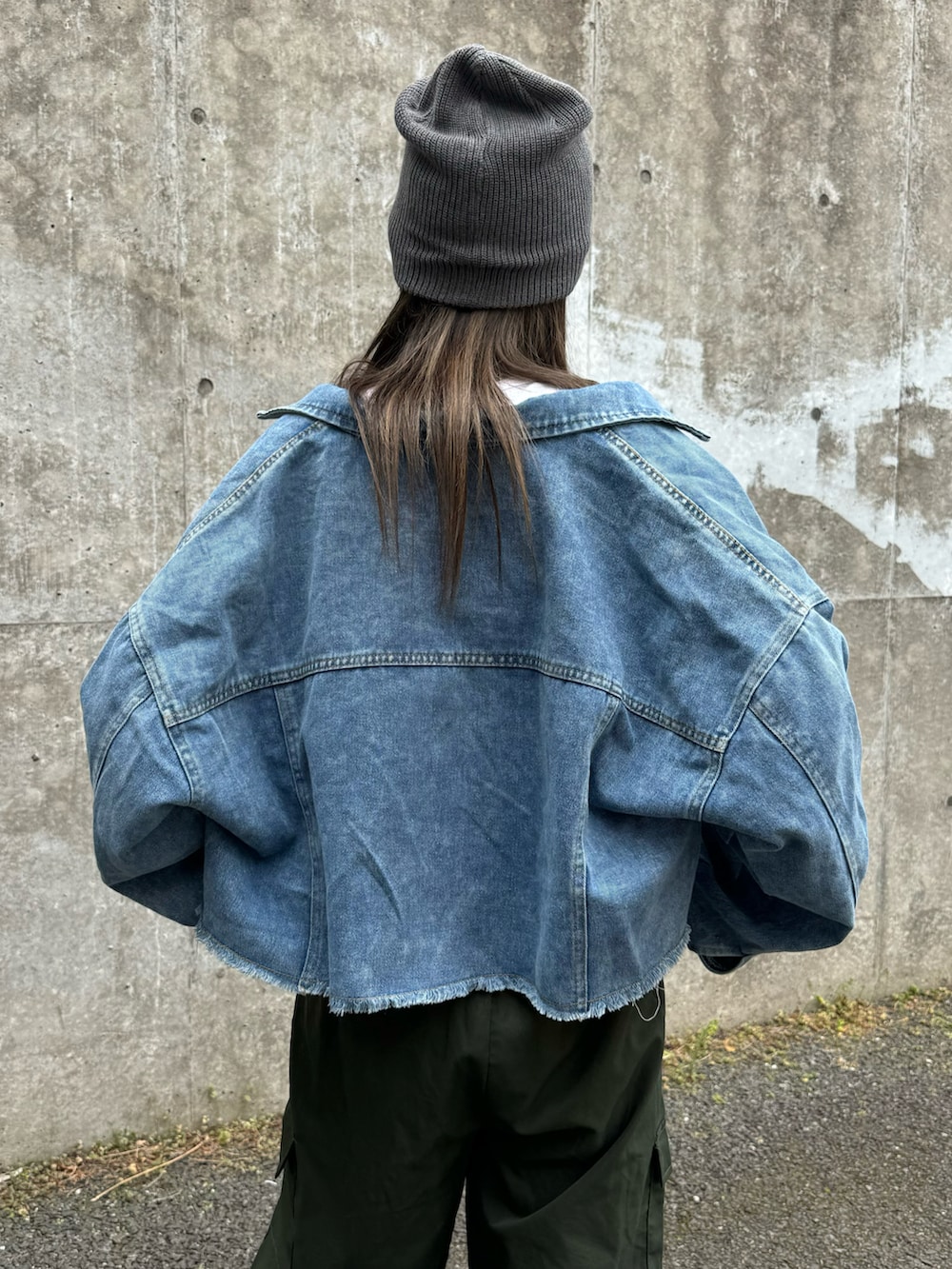 ブルー系のデニムジャケット、グリーン系のカーゴパンツ、ホワイト系のスニーカーを着用したレディースの春コーディネートの5枚目の写真