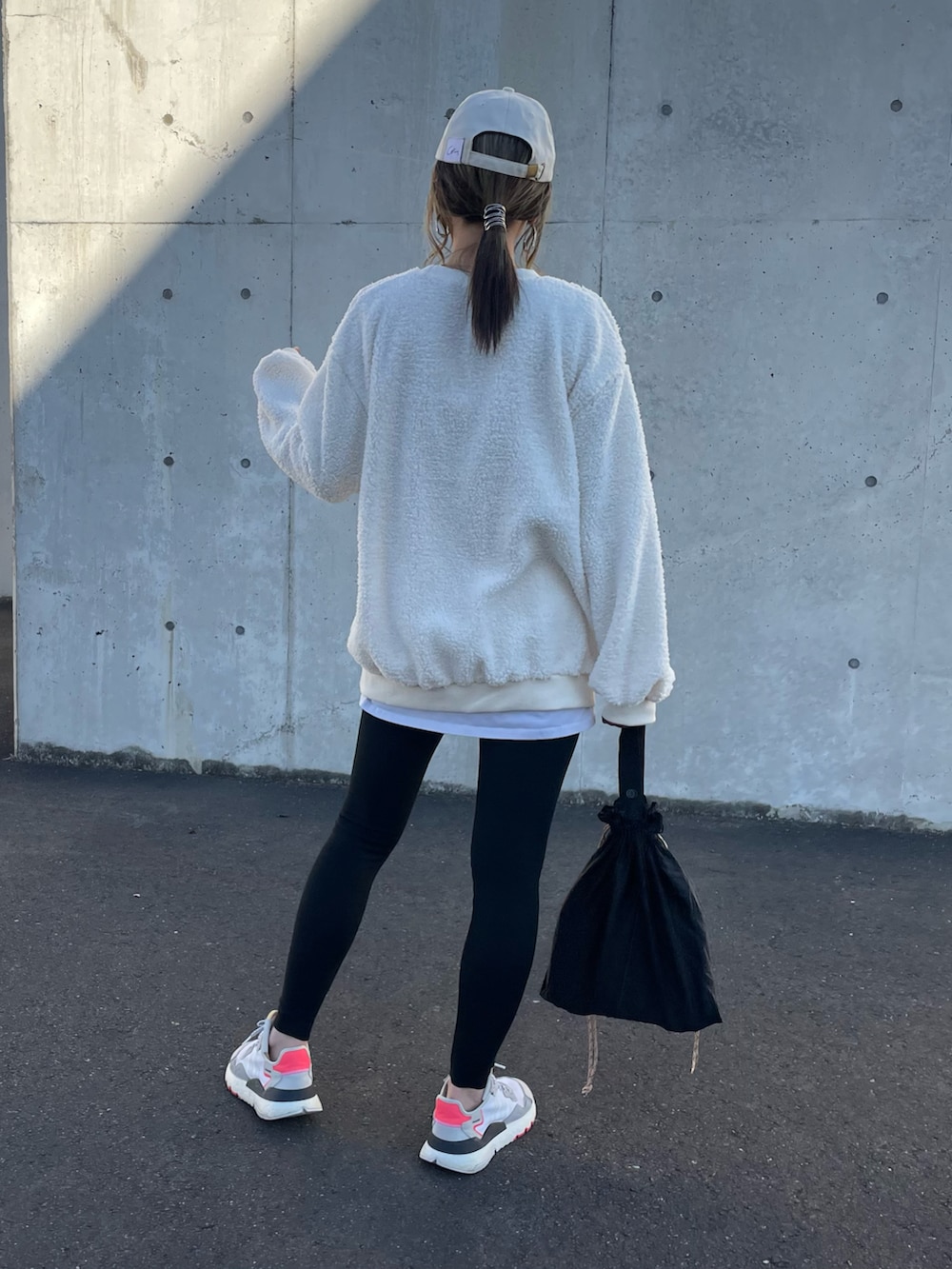 ホワイト系のスウェット、ホワイト系のその他パンツ、ブラック系のその他パンツを着用したレディースの冬コーディネートの3枚目の写真