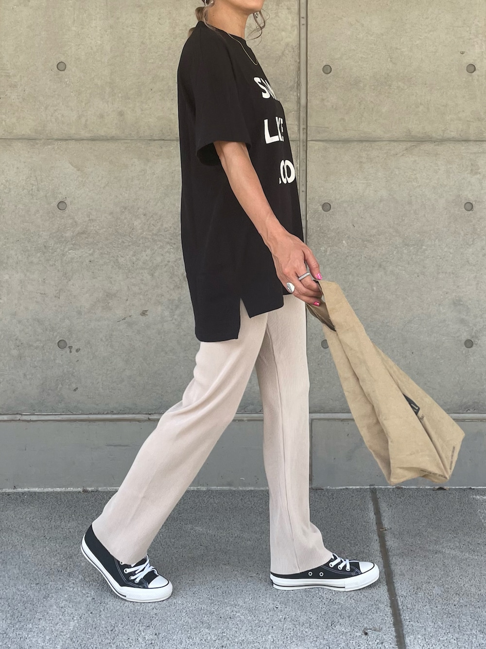 ブラック系のTシャツ/カットソー、ブラック系のスニーカー、その他のエコバッグ/サブバッグを着用したレディースの夏コーディネートの4枚目の写真