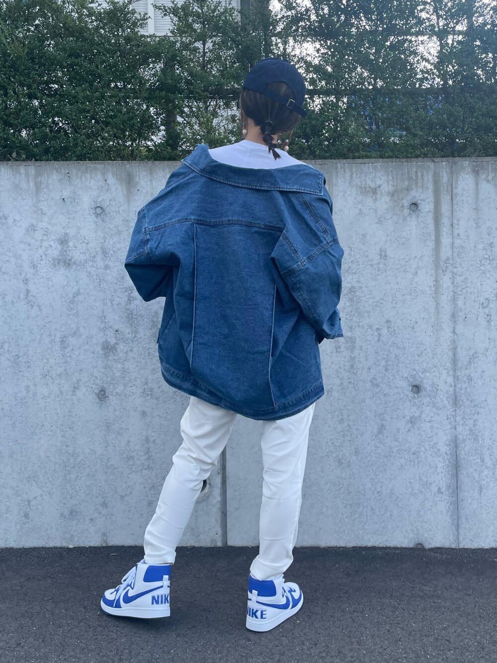 ブルー系のデニムジャケット、ホワイト系のその他パンツ、ブルー系のスニーカーを着用したレディースの秋コーディネートの3枚目の写真