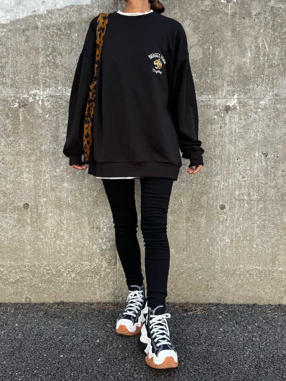 ブラック系のスウェット、ブラウン系のトートバッグ、ブラック系のその他パンツを着用したレディースの秋コーディネートの3枚目の写真