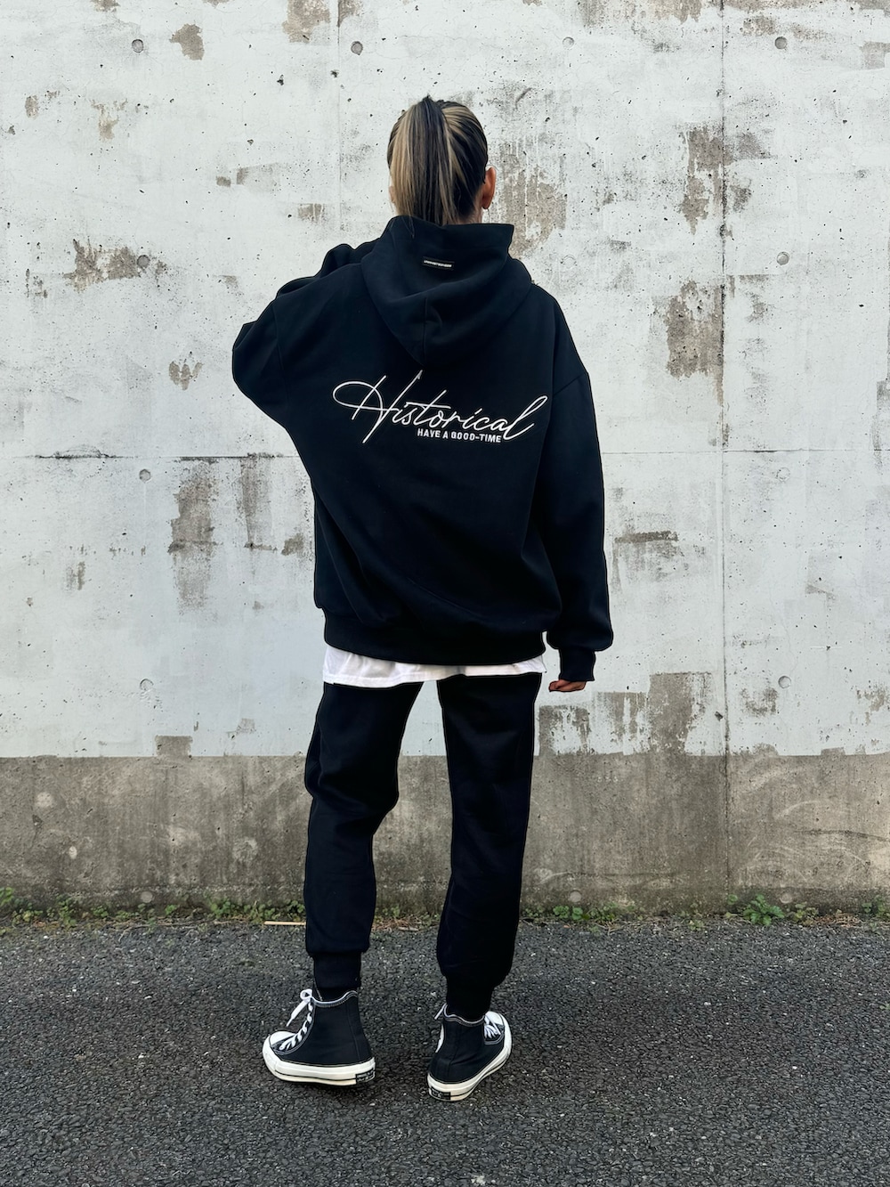 ブラック系のパーカー、ブラック系のスウェットパンツ、ブラック系のスニーカーを着用したレディースの冬コーディネートの2枚目の写真