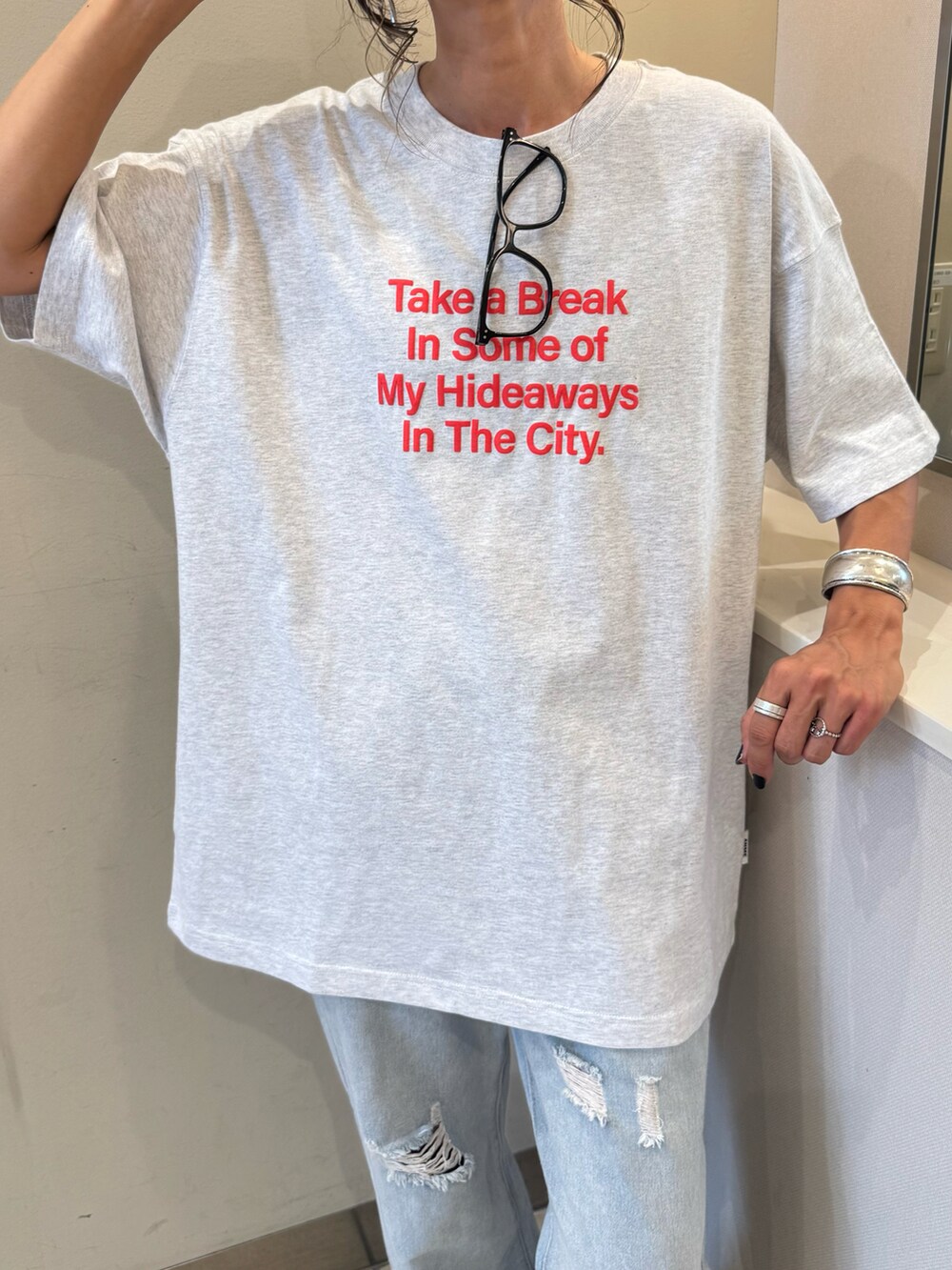 ホワイト系のスニーカー、グレー系のTシャツ/カットソー、ブルー系のデニムパンツを着用したレディースの夏コーディネートの2枚目の写真