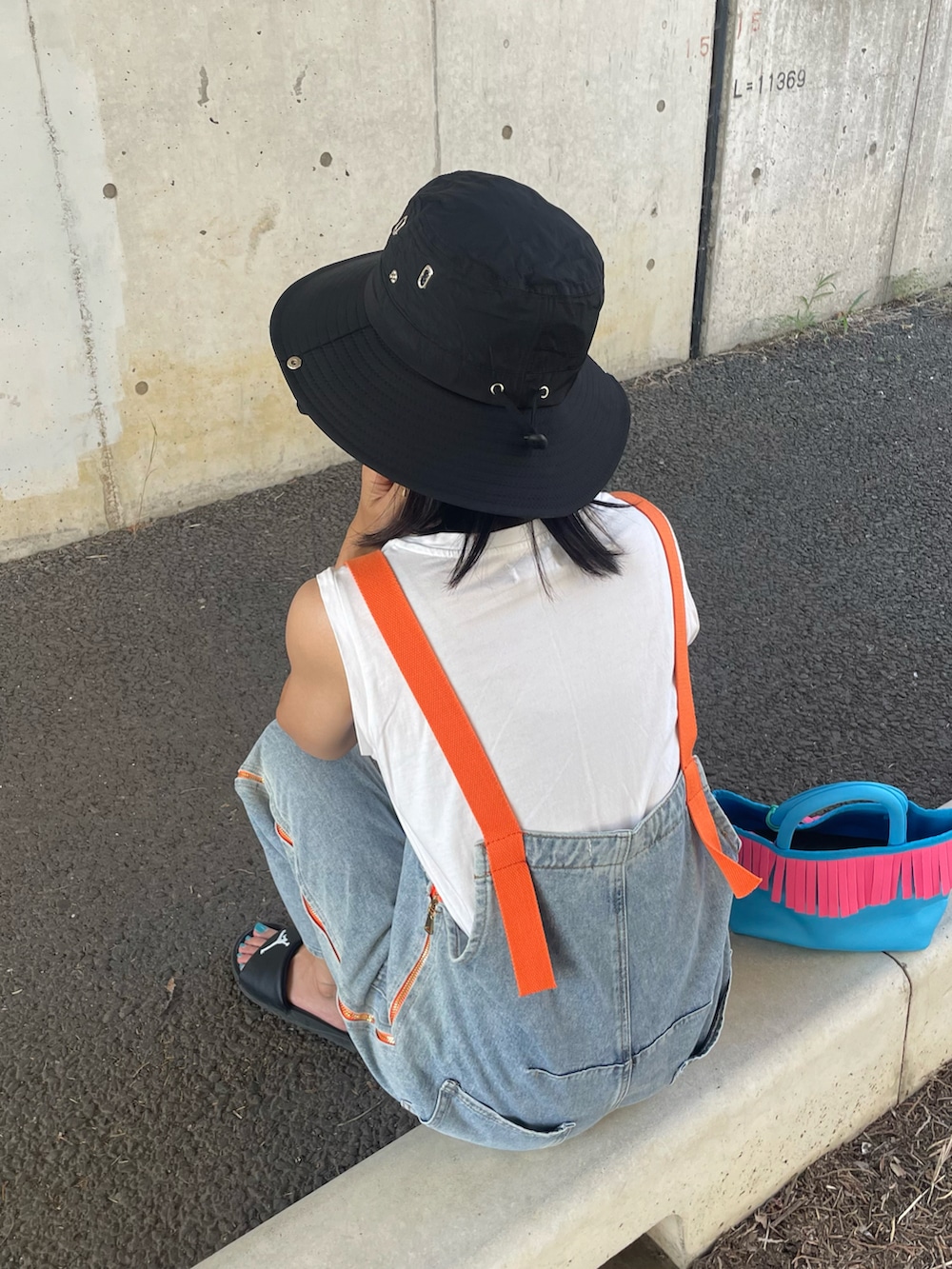 ブルー系のサロペット/オーバーオール、ホワイト系のTシャツ/カットソー、ブラック系のサンダルを着用したレディースの夏コーディネートの4枚目の写真