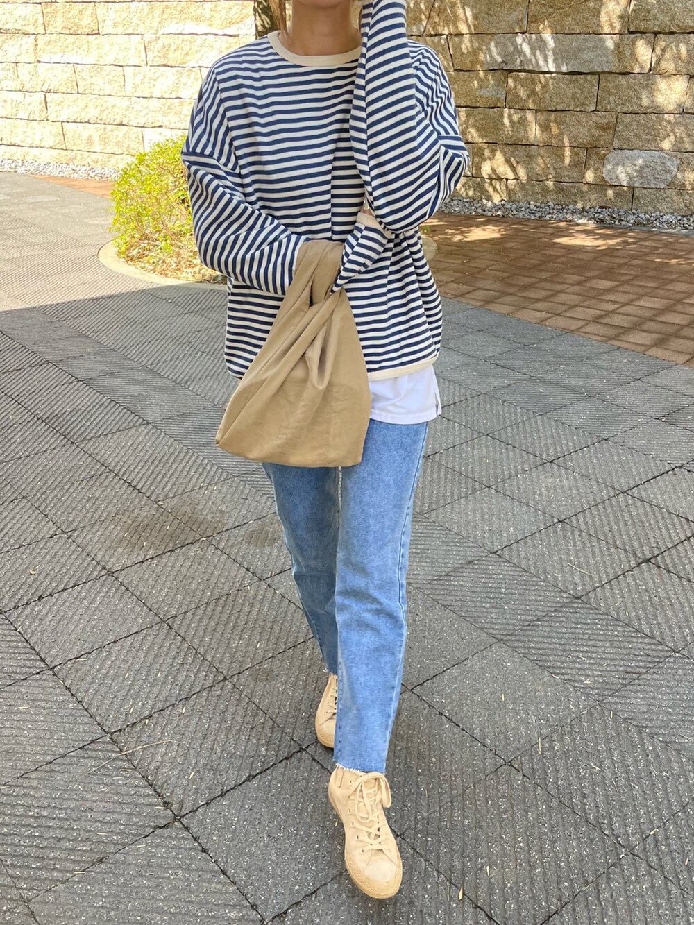 ブルー系のTシャツ/カットソー、ブルー系のデニムパンツ、その他のエコバッグ/サブバッグを着用したレディースの春コーディネートの2枚目の写真