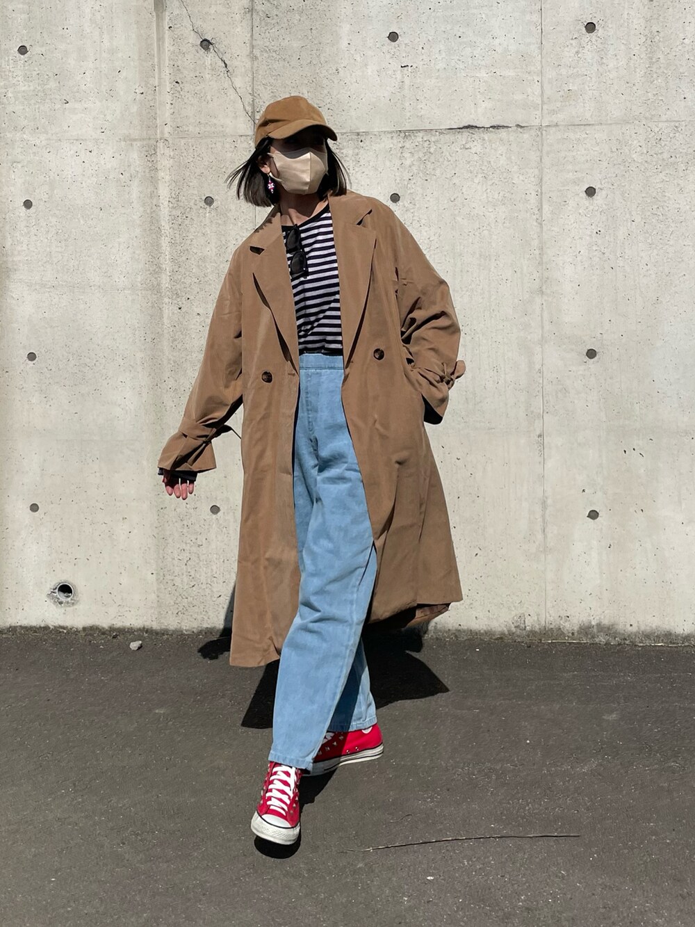 ブラック系のTシャツ/カットソー、ブラウン系のトレンチコート、ブルー系のデニムパンツを着用したレディースの冬コーディネートの2枚目の写真