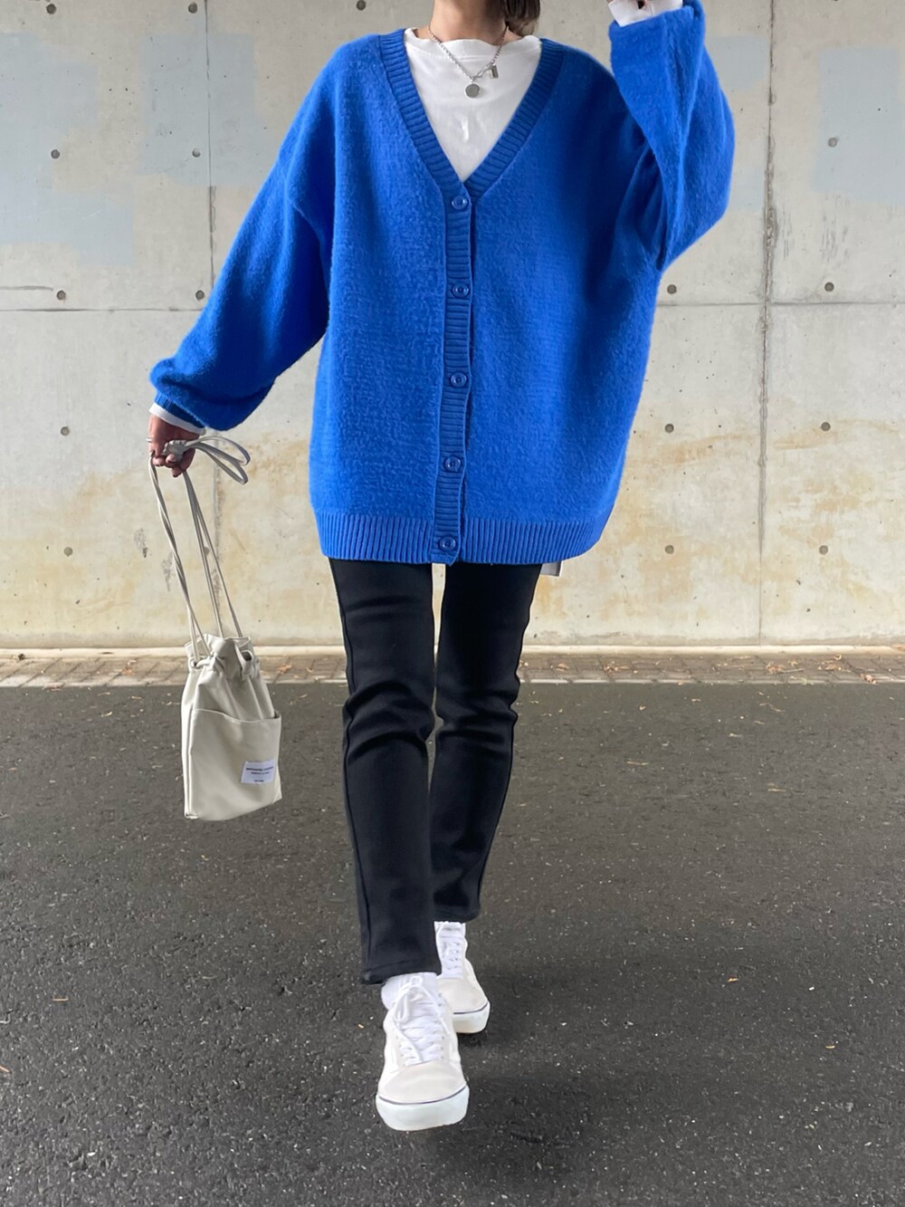 ブルー系のカーディガン/ボレロ、ブラック系のデニムパンツ、ホワイト系のスニーカーを着用したレディースの冬コーディネートの2枚目の写真