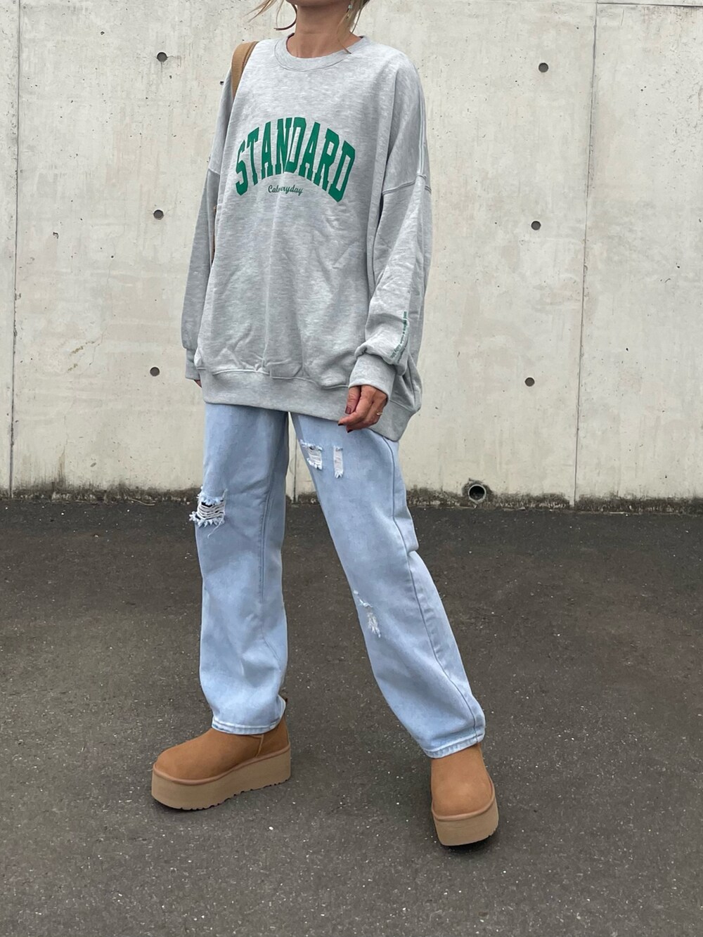 ブルー系のデニムパンツ、その他のトートバッグ、ブラウン系のブーツを着用したレディースの秋コーディネートの4枚目の写真