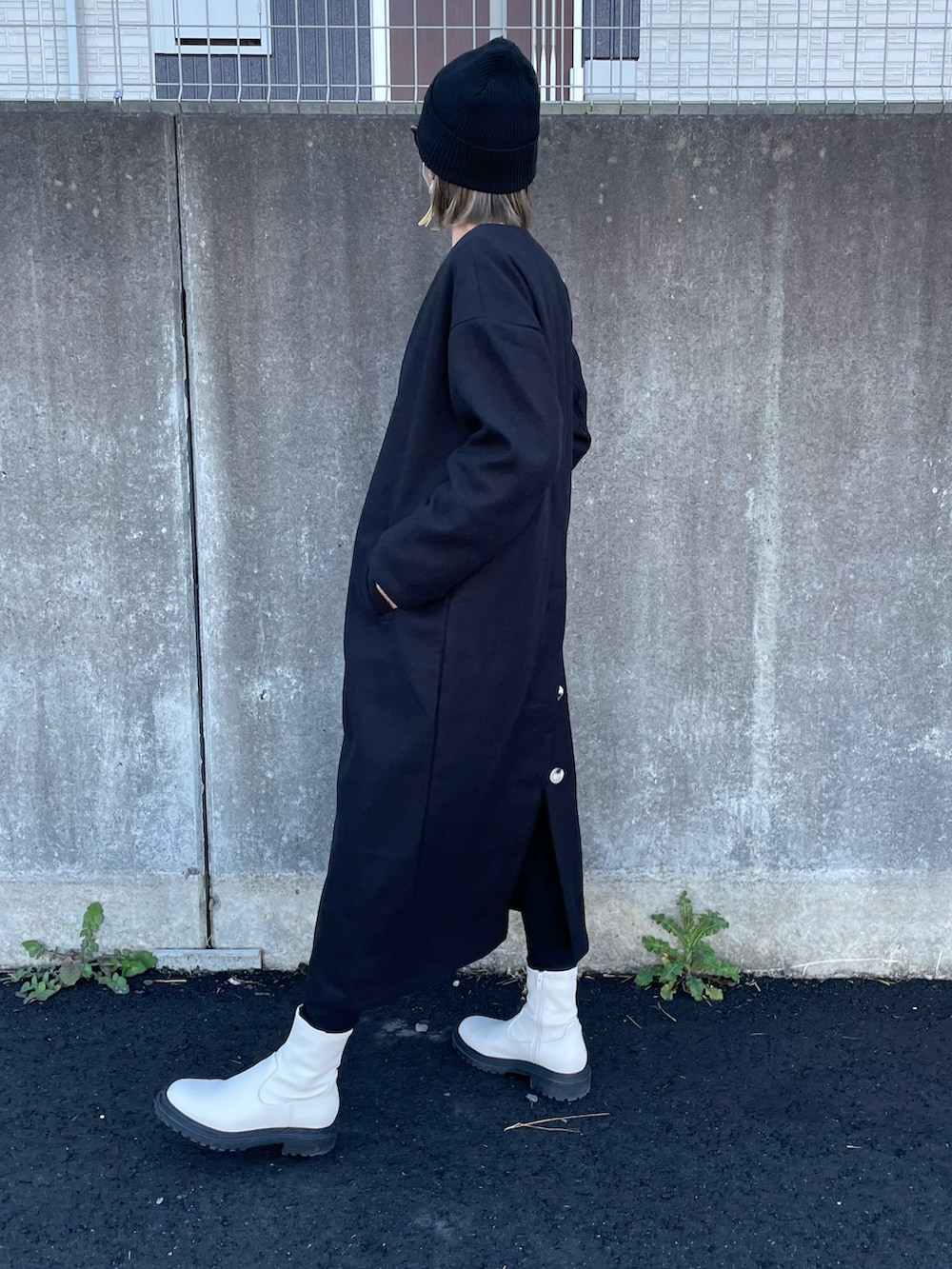 イエロー系のスウェット、ブラック系のノーカラーコート、ブラック系のその他パンツを着用したレディースの秋コーディネートの2枚目の写真