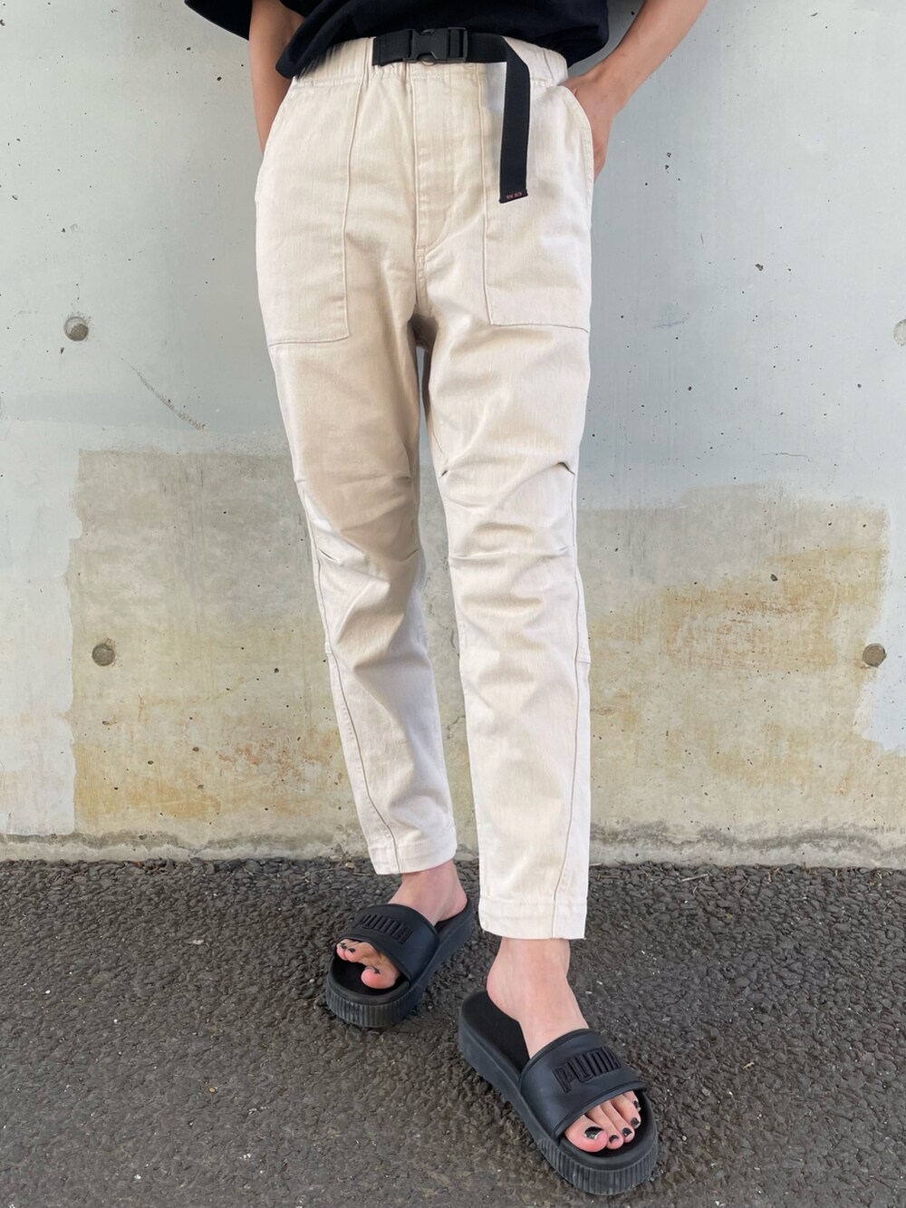 ブラック系のTシャツ/カットソー、ホワイト系のその他パンツ、ブラック系のサンダルを着用したレディースの春コーディネートの4枚目の写真