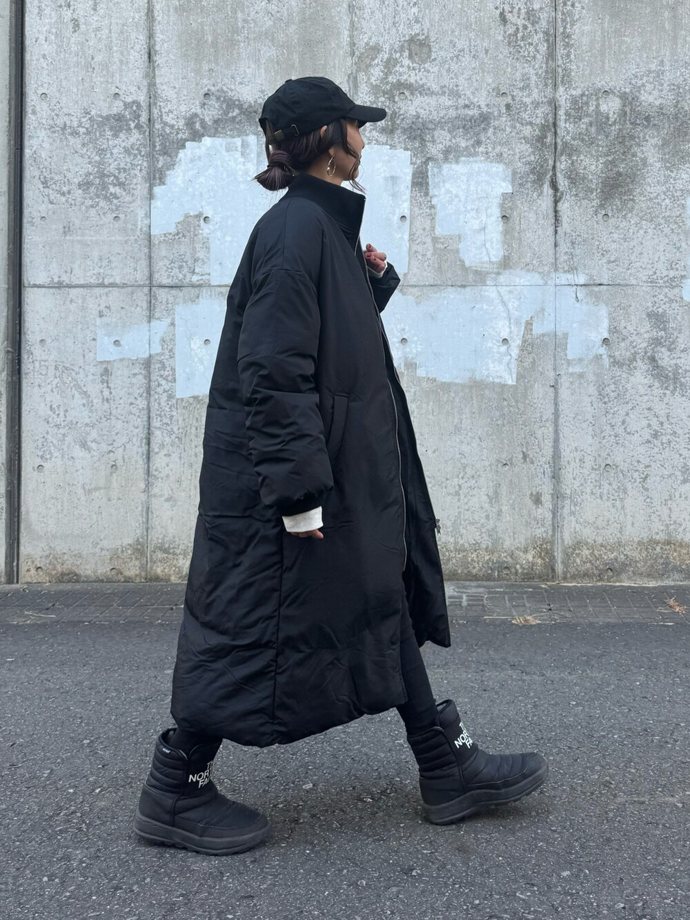 ブラック系のその他アウター、ホワイト系のスウェット、ブラック系のその他パンツを着用したレディースの冬コーディネートの3枚目の写真