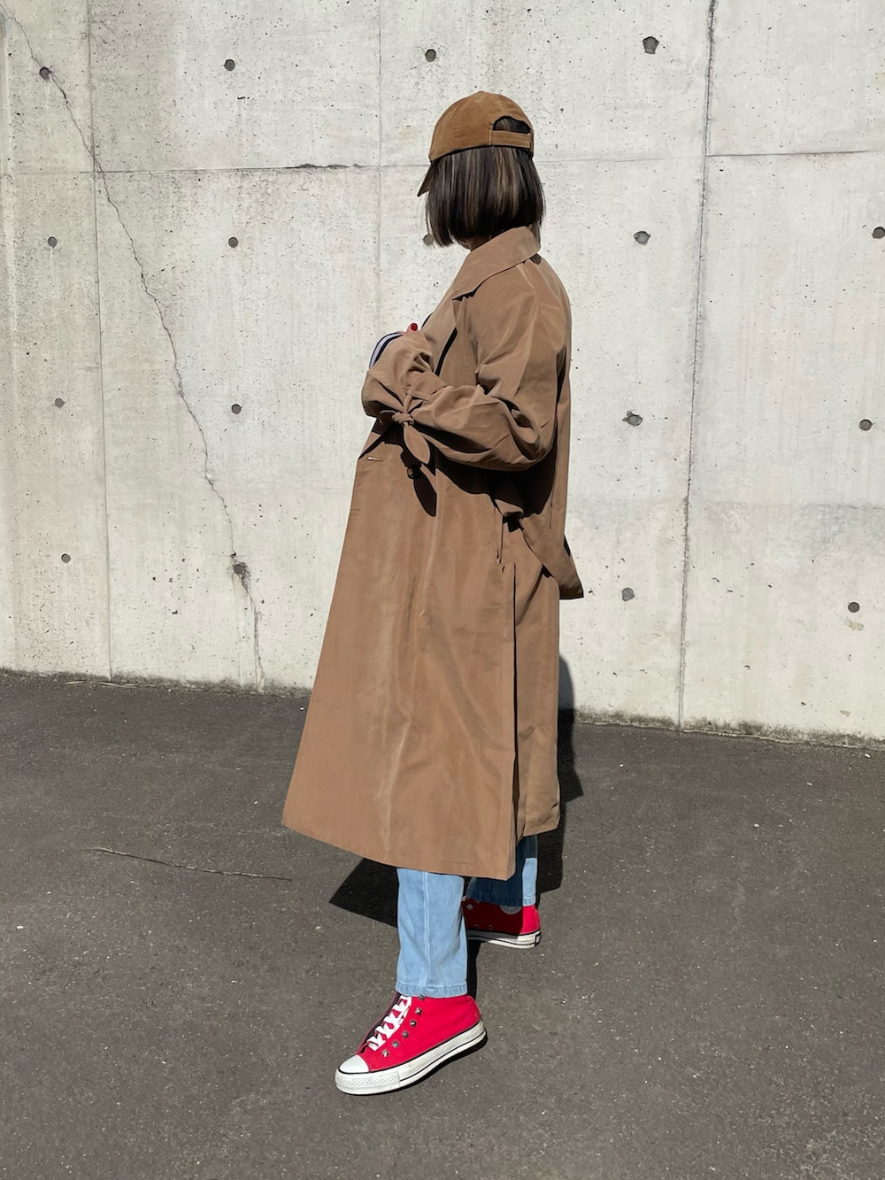 ブラック系のTシャツ/カットソー、ブラウン系のトレンチコート、ブルー系のデニムパンツを着用したレディースの冬コーディネートの3枚目の写真
