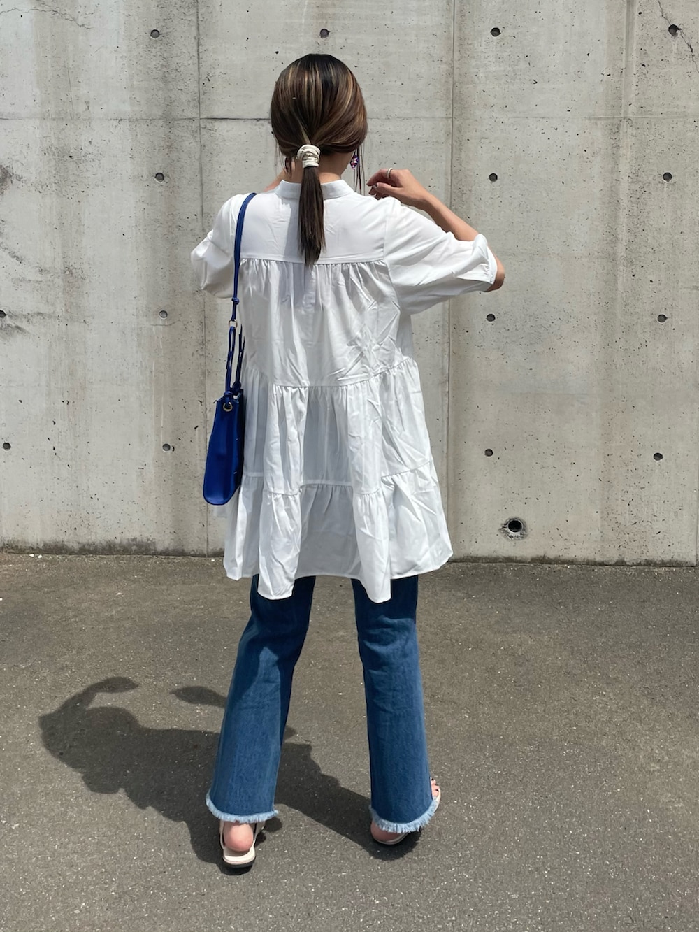 ホワイト系のシャツ/ブラウス、ブルー系のデニムパンツ、ブルー系のショルダーバッグを着用したレディースの春コーディネートの2枚目の写真