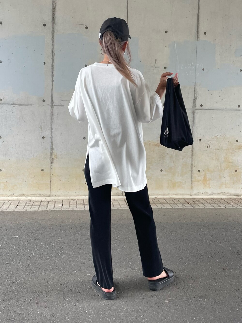 ホワイト系のTシャツ/カットソー、ブラック系のサンダル、その他のエコバッグ/サブバッグを着用したレディースの夏コーディネートの4枚目の写真