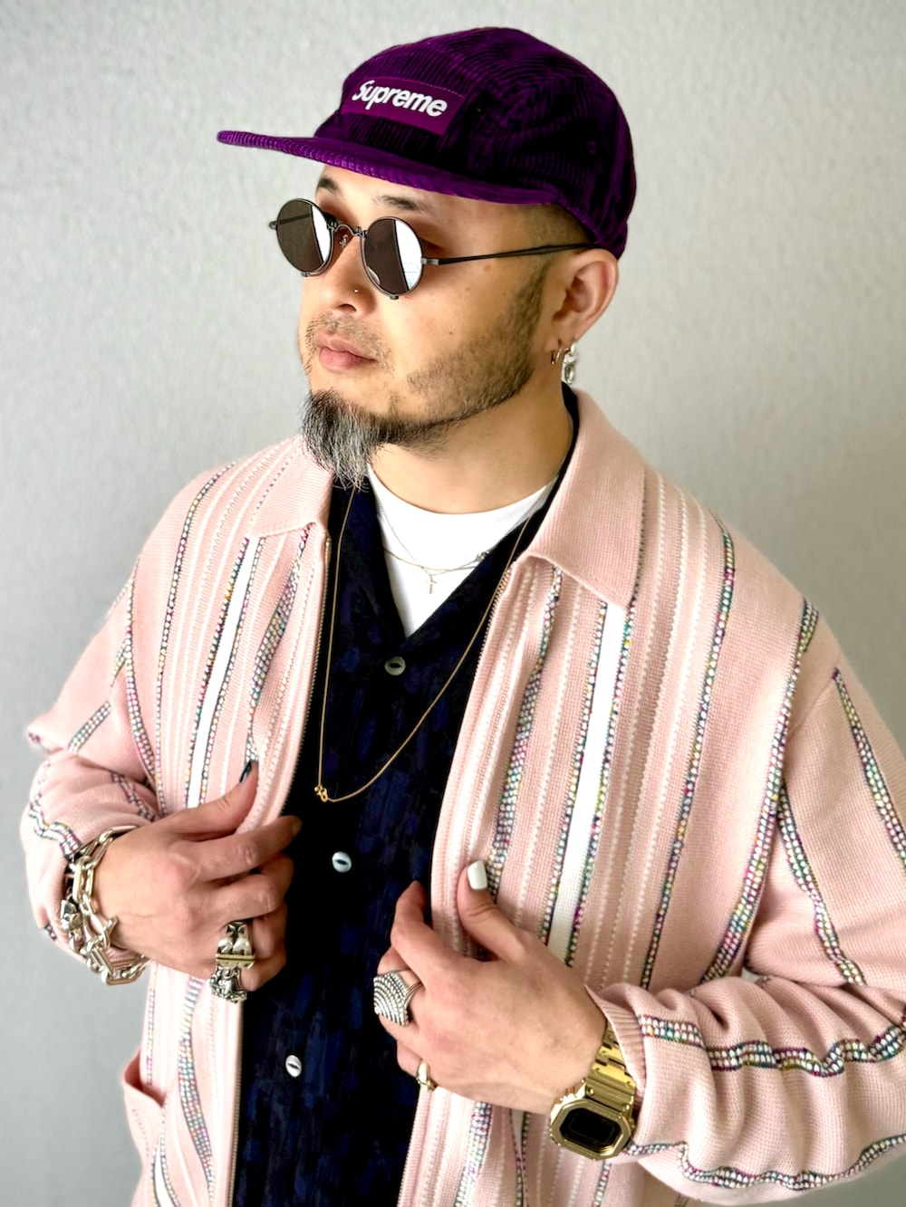 ブラック系のデニムパンツ、ブラック系のブーツ、ピンク系のカーディガン/ボレロを着用したメンズの冬コーディネートの5枚目の写真