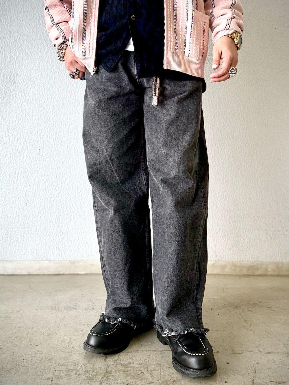 ブラック系のデニムパンツ、ブラック系のブーツ、ピンク系のカーディガン/ボレロを着用したメンズの冬コーディネートの4枚目の写真