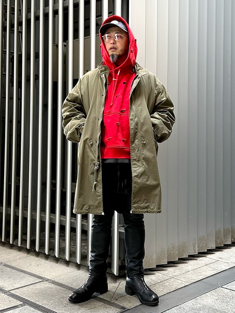 レッド系のパーカー、ブラック系のその他パンツ、ブラック系のブーツを着用したメンズの春コーディネートの4枚目の写真