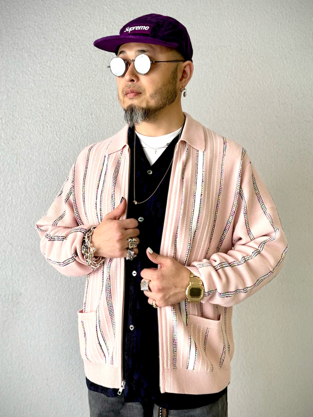 ブラック系のデニムパンツ、ブラック系のブーツ、ピンク系のカーディガン/ボレロを着用したメンズの冬コーディネートの3枚目の写真