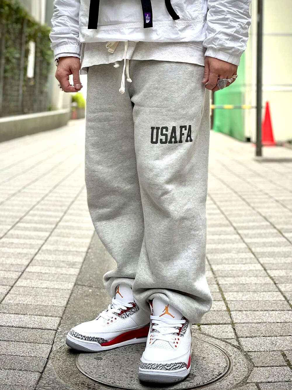 グレー系のスウェットパンツ、ホワイト系のスニーカー、ベージュ系のTシャツ/カットソーを着用したメンズの春コーディネートの4枚目の写真