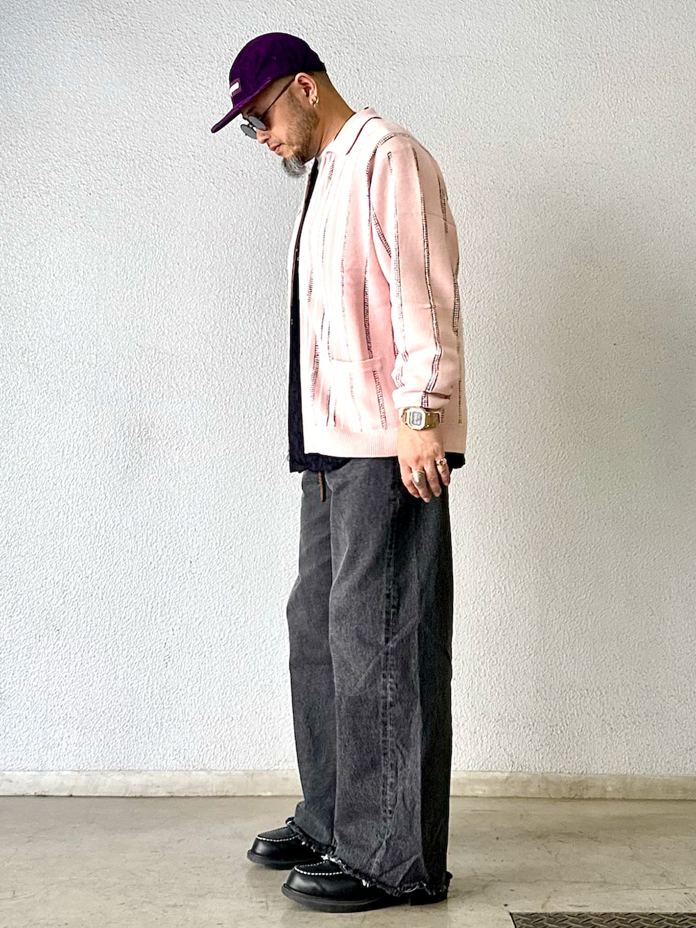 ブラック系のデニムパンツ、ブラック系のブーツ、ピンク系のカーディガン/ボレロを着用したメンズの冬コーディネートの2枚目の写真