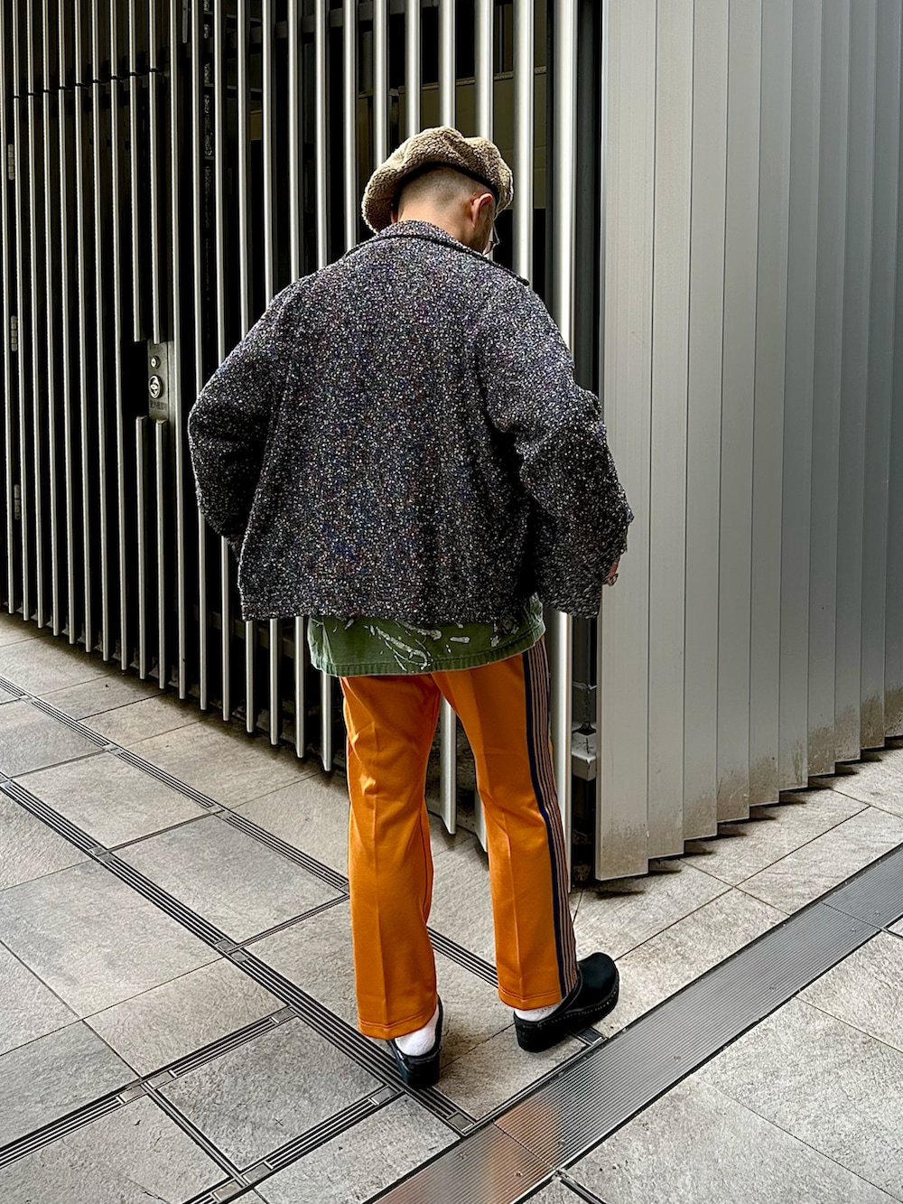 イエロー系のパンツ、ブラック系のサンダル、グレー系のブルゾンを着用したメンズの秋コーディネートの2枚目の写真