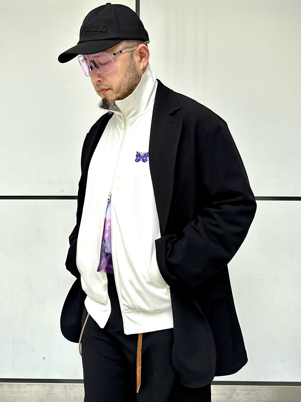 ブラック系のスラックス、ブラック系のテーラードジャケット、ホワイト系のジャージを着用したメンズの春コーディネートの4枚目の写真