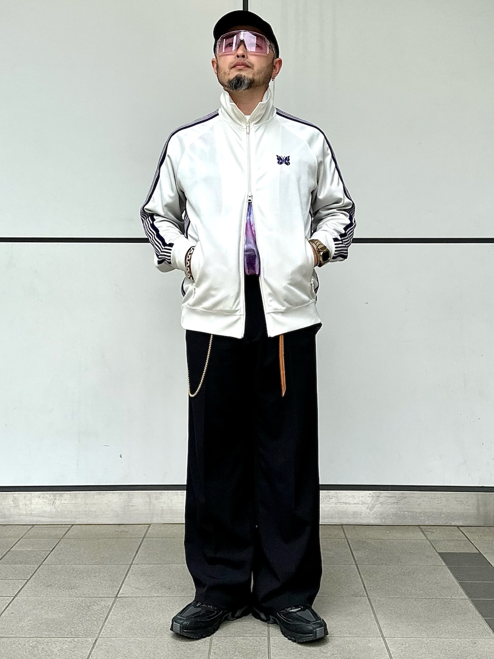 ブラック系のスラックス、ブラック系のテーラードジャケット、ホワイト系のジャージを着用したメンズの春コーディネートの3枚目の写真