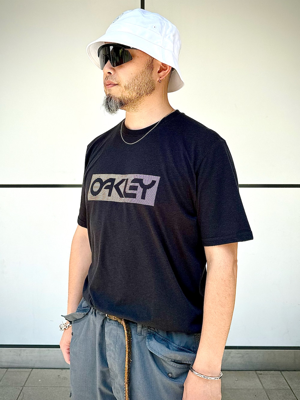 「夏コーデ、カジュアルコーデ、ストリート、モノトーン、リラックススタイル、タックイン、バケットハット、サングラス、ショートパンツ、ハーフパンツ、モノトーンコーデ、シルバーアクセサリー、Oakley、カーゴパンツ、オーバーサイズ」｜「OAKLEYのアイテム（Tシャツ/カットソー、ブラック系）」を使った、Yoshihito Hayashiさん（メンズ・170cm）の夏コーディネートの3枚目の写真