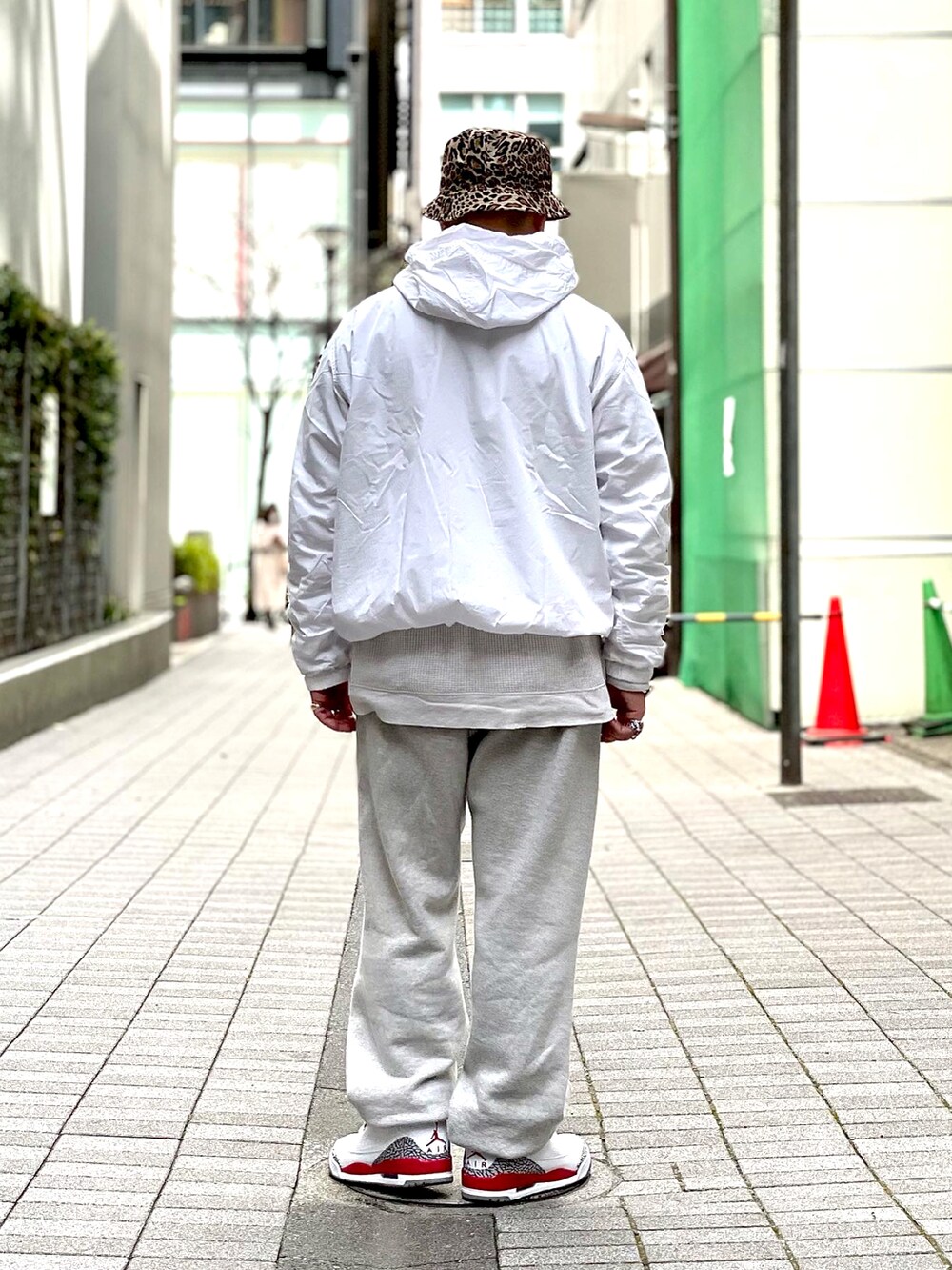 グレー系のスウェットパンツ、ホワイト系のスニーカー、ベージュ系のTシャツ/カットソーを着用したメンズの春コーディネートの2枚目の写真