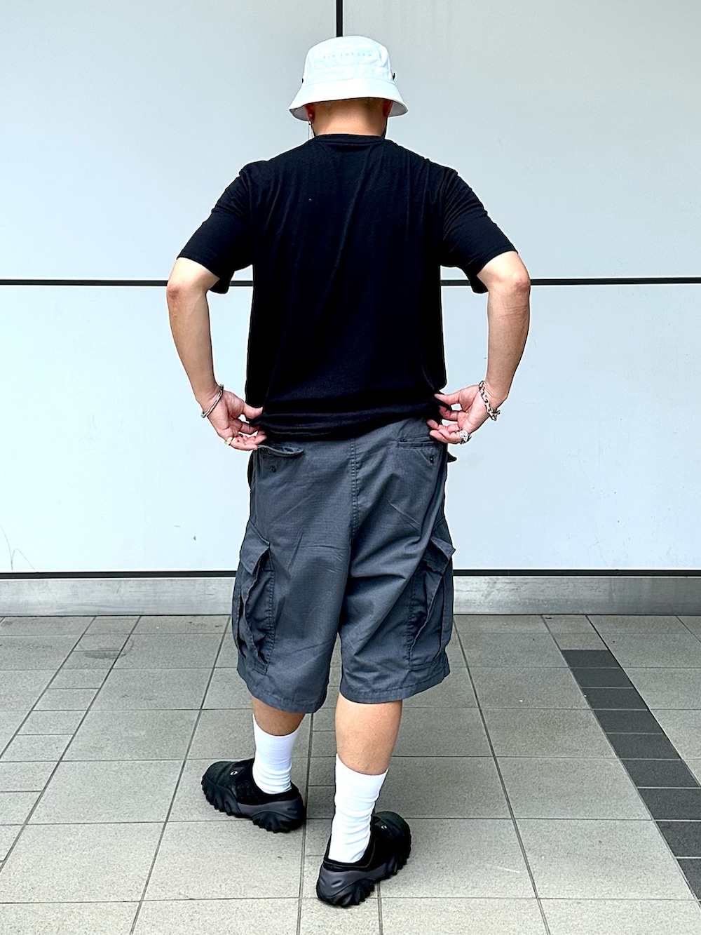 「夏コーデ、カジュアルコーデ、ストリート、モノトーン、リラックススタイル、タックイン、バケットハット、サングラス、ショートパンツ、ハーフパンツ、モノトーンコーデ、シルバーアクセサリー、Oakley、カーゴパンツ、オーバーサイズ」｜「OAKLEYのアイテム（Tシャツ/カットソー、ブラック系）」を使った、Yoshihito Hayashiさん（メンズ・170cm）の夏コーディネートの2枚目の写真
