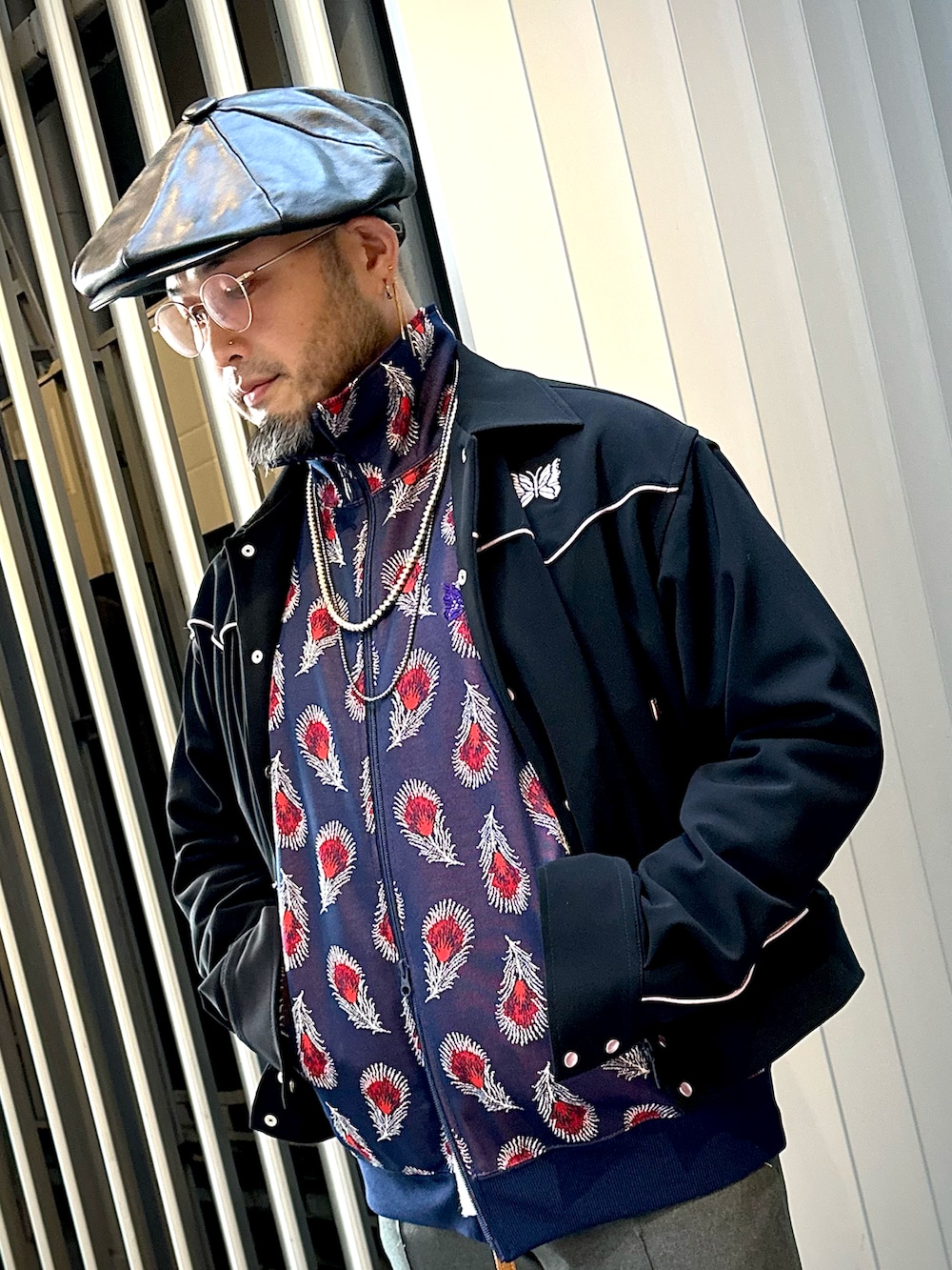 グリーン系のモッズコート、ブラック系のブルゾン、ブルー系のジャージを着用したメンズの秋コーディネートの4枚目の写真