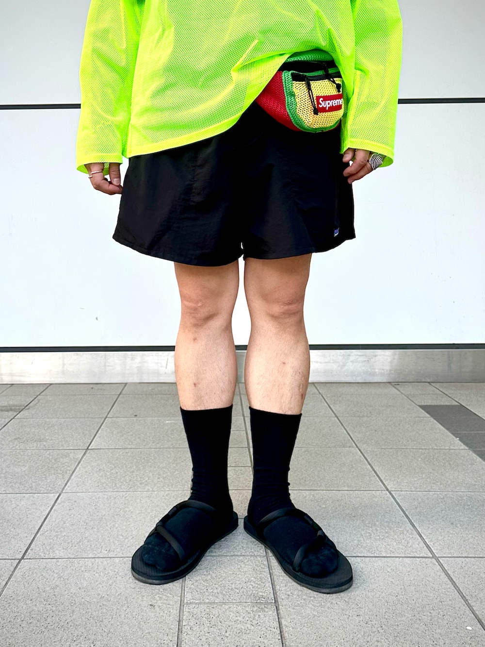 「夏コーデ、大人コーデ、カジュアルコーデ、ハーフパンツ、ショートパンツ、サングラス、バケットハット、レイヤードスタイル、ウエストポーチ、サンダル、サンダルに靴下、ネオンカラー、アウトドアスタイル、supreme、patagonia」｜「South2 West8のアイテム（Tシャツ/カットソー、イエロー系）」を使った、Yoshihito Hayashiさん（メンズ・170cm）の夏コーディネートの4枚目の写真