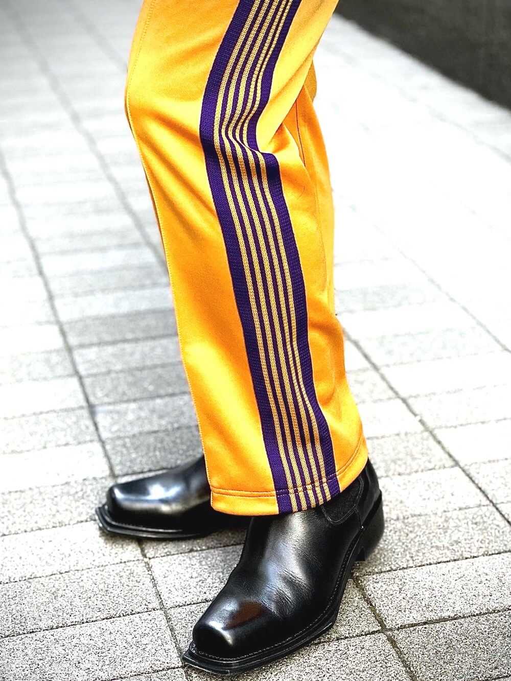 イエロー系のパンツ、イエロー系のジャージ、ブラック系のブーツを着用したメンズの冬コーディネートの5枚目の写真