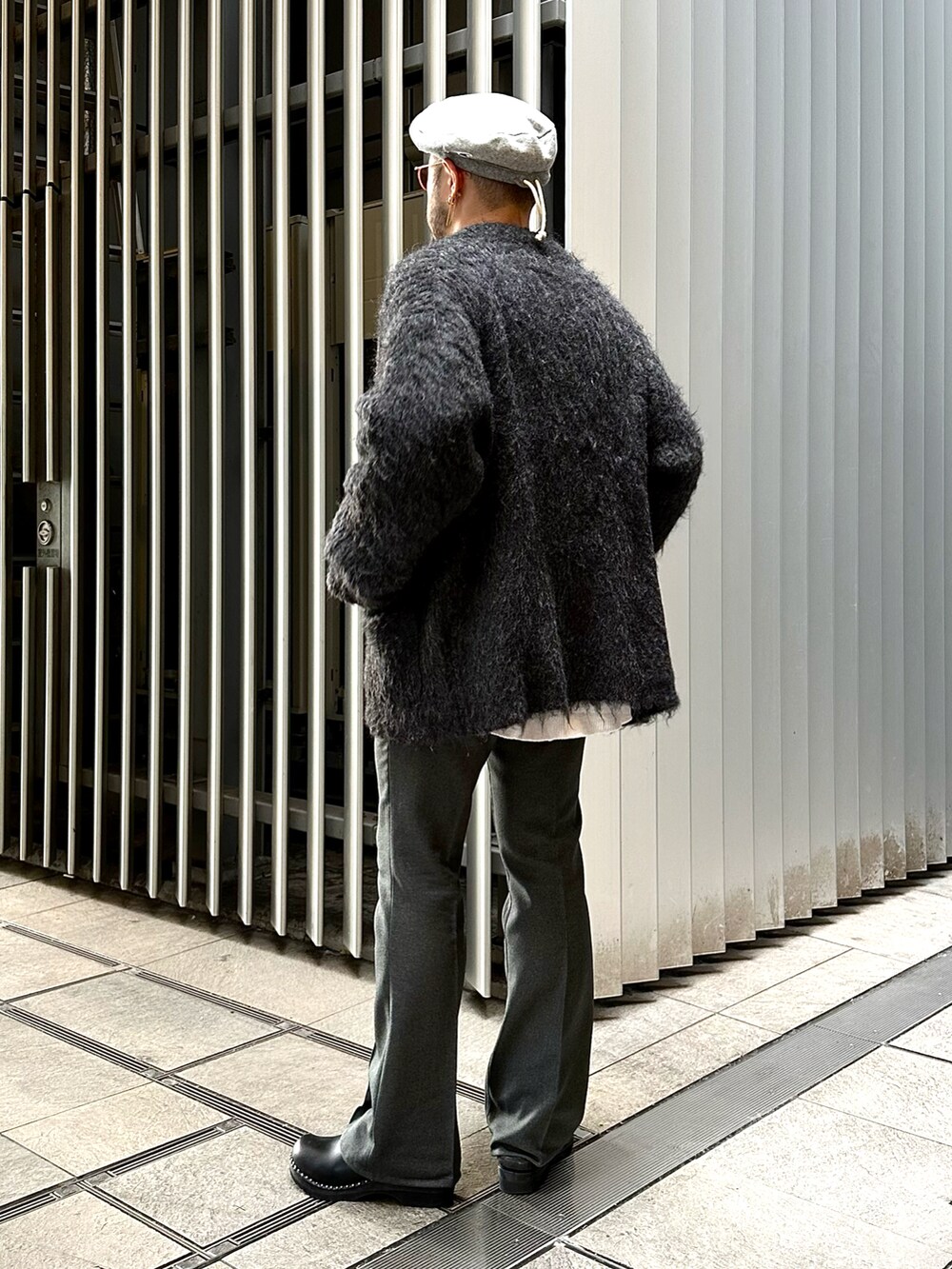ブラック系のニット/セーター、グレー系のパンツ、ブラック系のサンダルを着用したメンズの冬コーディネートの2枚目の写真