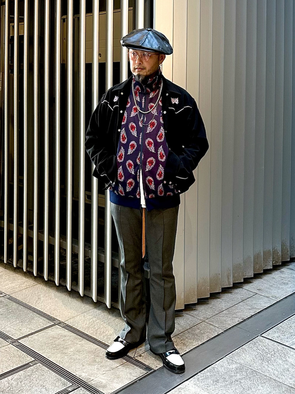 グリーン系のモッズコート、ブラック系のブルゾン、ブルー系のジャージを着用したメンズの秋コーディネートの2枚目の写真