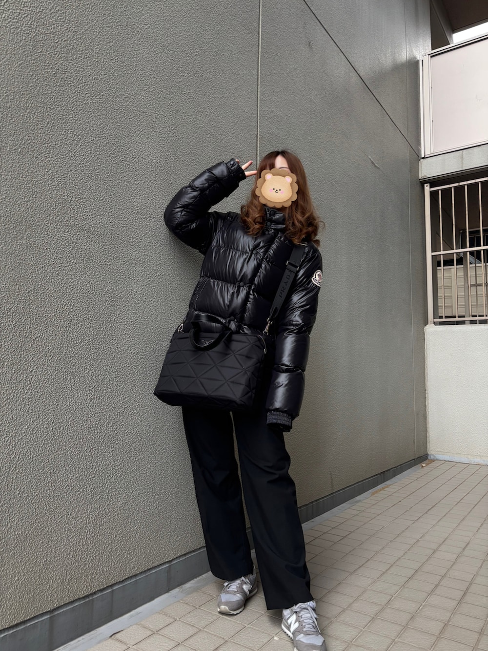 グレー系のスニーカー、ブラック系のバッグ、ブラック系のダウンジャケット/コートを着用したレディースの冬コーディネートの2枚目の写真
