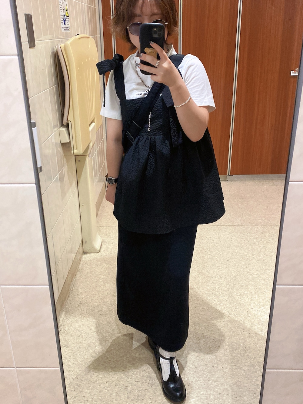 ブラック系のスカート、ブラック系のTシャツ/カットソー、ホワイト系のTシャツ/カットソーを着用したレディースの夏コーディネートの2枚目の写真