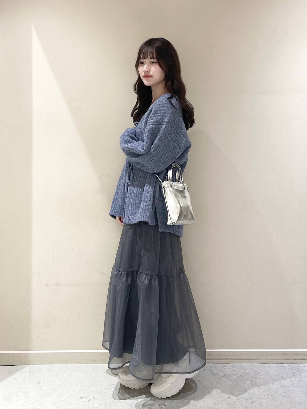 ホワイト系のキャミソール、グレー系のショルダーバッグ、ホワイト系のスニーカーを着用したレディースの冬コーディネートの2枚目の写真