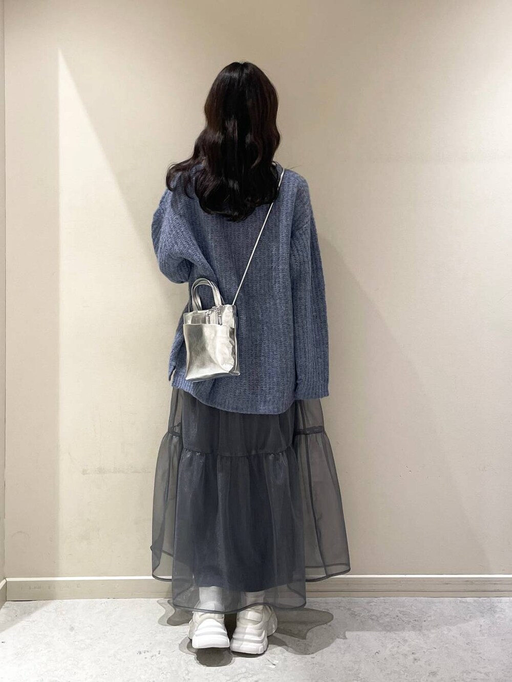 ホワイト系のキャミソール、グレー系のショルダーバッグ、ホワイト系のスニーカーを着用したレディースの冬コーディネートの3枚目の写真
