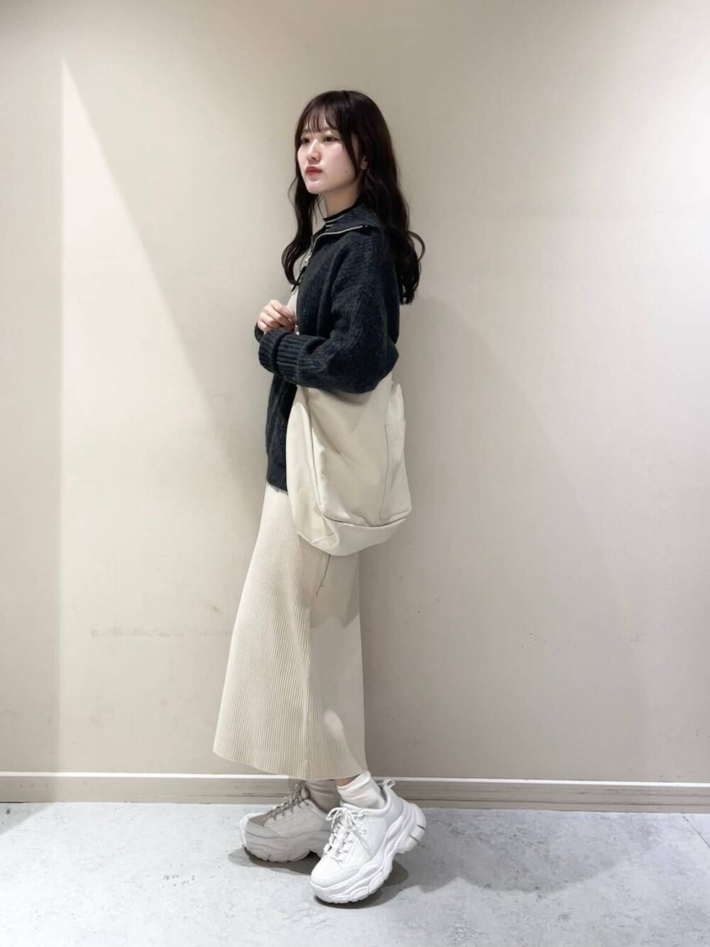 ホワイト系のボディバッグ/ウエストポーチ、ブラック系のTシャツ/カットソー、ホワイト系のワンピースを着用したレディースの冬コーディネートの2枚目の写真