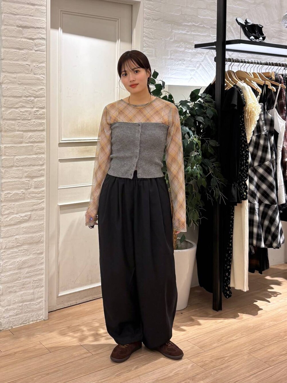 ブラウン系のスニーカー、ブラック系のその他パンツ、グレー系のチューブトップを着用したレディースの秋コーディネートの4枚目の写真